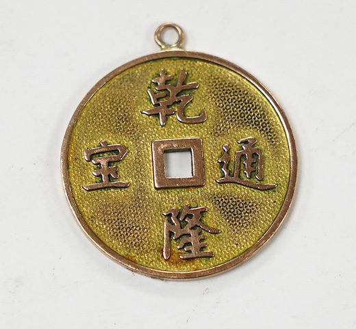 A Chinese 14k cash shaped charm, inscribed 'Qianlong tong bao', 25mm, 4.2 grams. Condition - fair